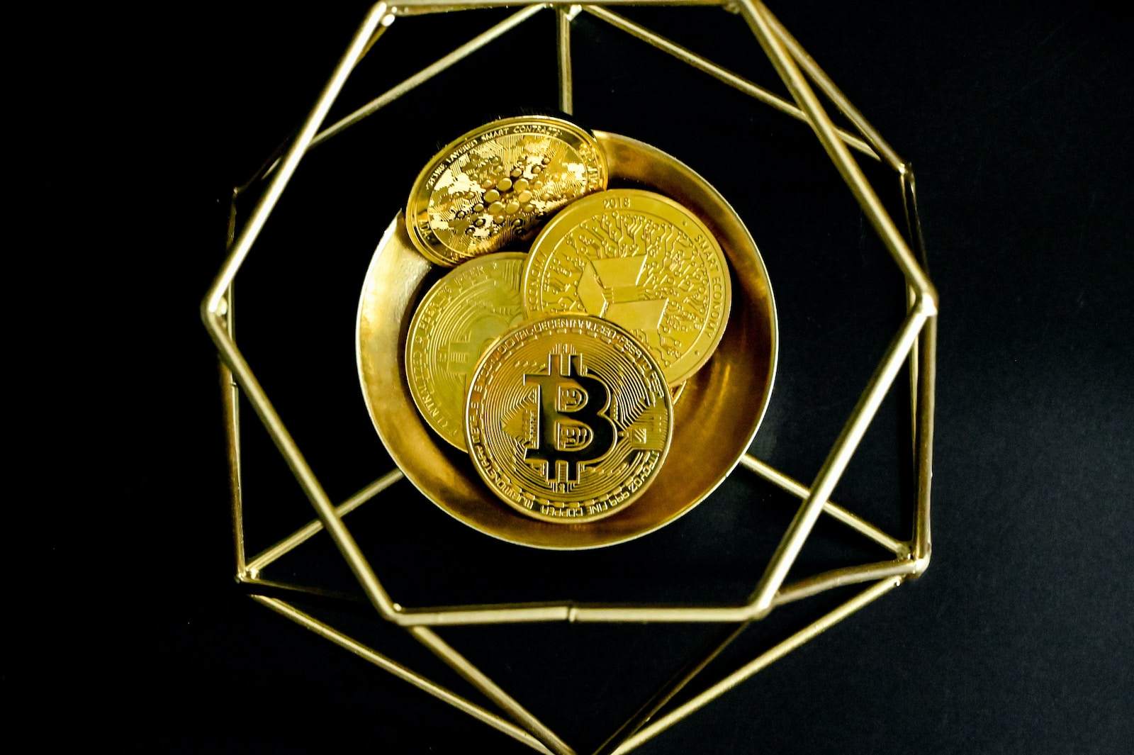 a golden bitcoin sitting on top of a gold plate